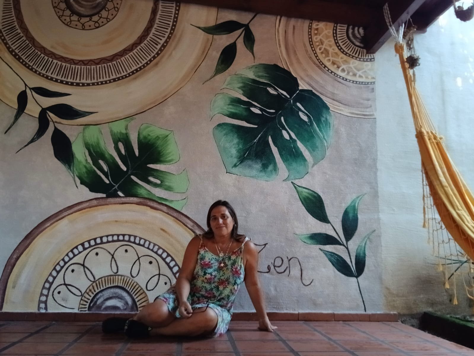 Alumna del Club Natureza sentada frente a su mural Zen